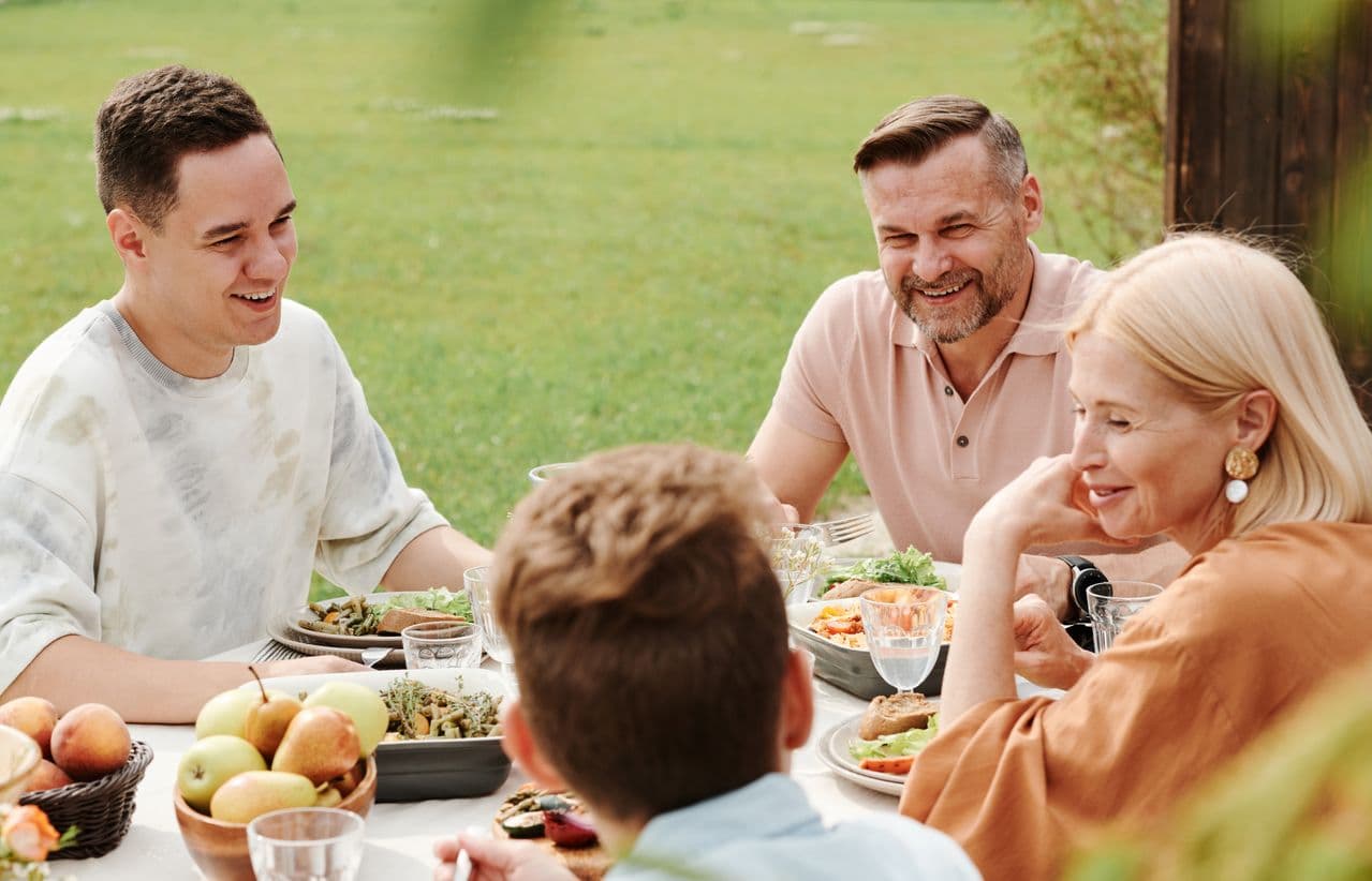 Parents with grown up sons eating outdoors